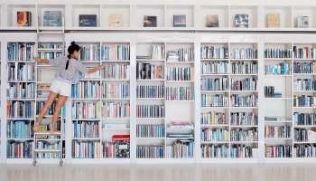 Empleada de una librería organizando los libros en las estanterías.