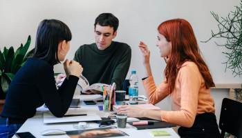 Drei Unternehmer*innen besprechen den Inhalt ihres Newsletters