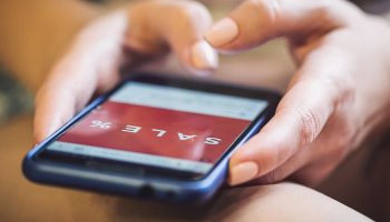 Ein Smartphone auf dessen Bildschirm das Wort Sales zu sehen ist